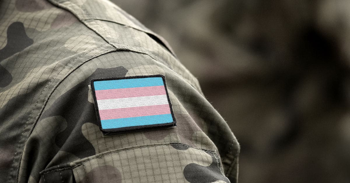 A close up image of a military uniform with a shoulder label depicting the transgender pride flag to illustrate transgender military personnel