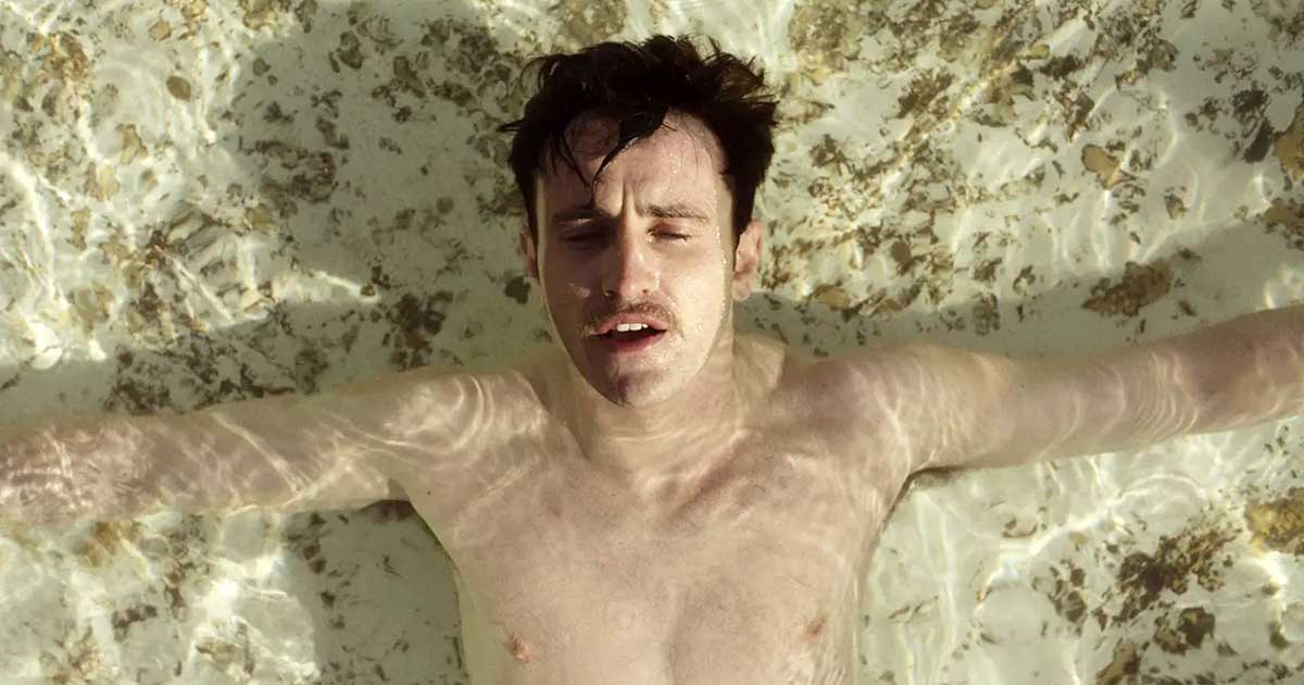 An image of Paul Mescal in The History of Sound, lying in shallow water with his eyes closed.
