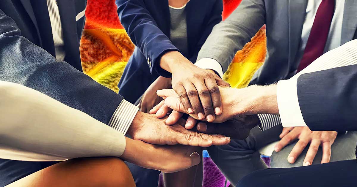 A close-up of the hands of diverse people wearing business wear, representing unity and inclusion through the South African Workplace Equality Index (SAWEI).