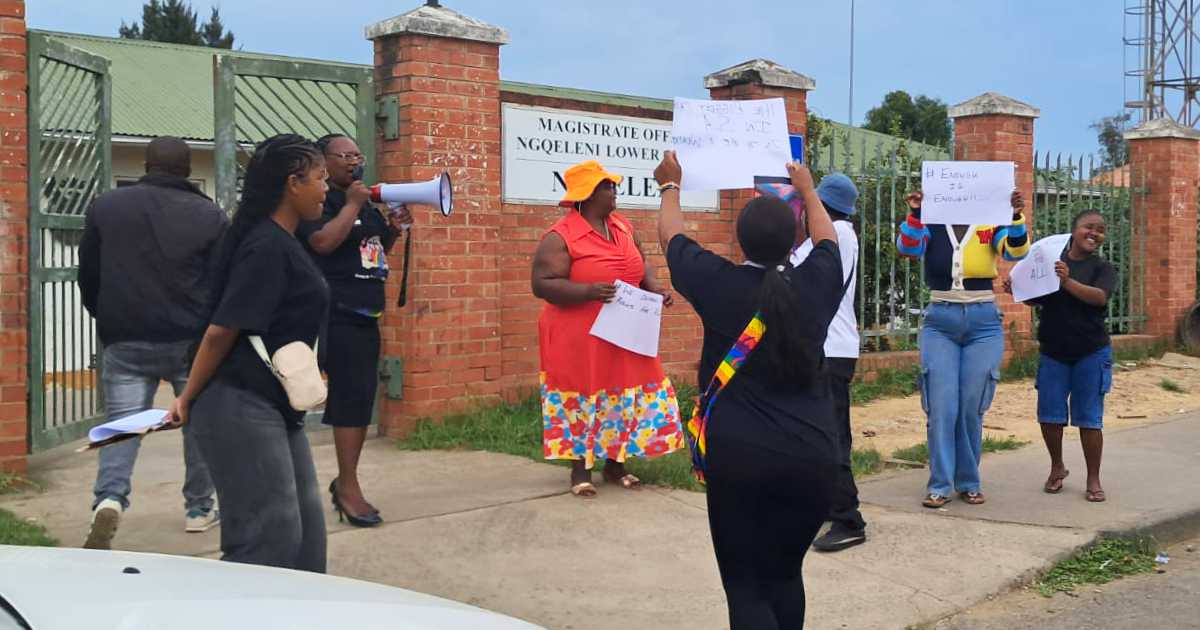 A photo of several members of the LGBTQIA+ community protesting outside the Ngqeleni Regional Court in support of the survivor of a “corrective rape” attack in the Eastern Cape.